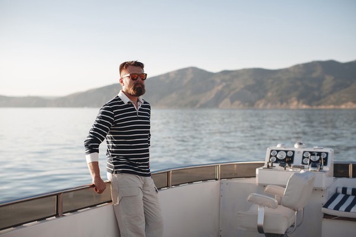 Well-dressed successful man standing by a marina dock.