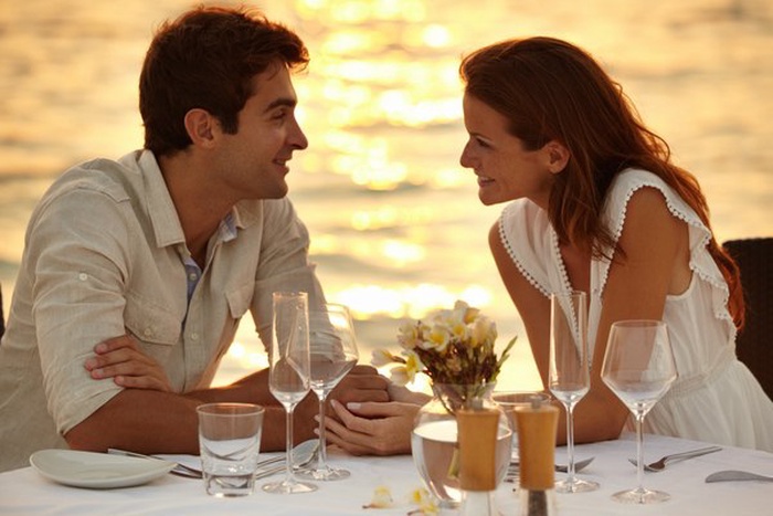 Affluent couple dining by lake at sunset in Oshawa