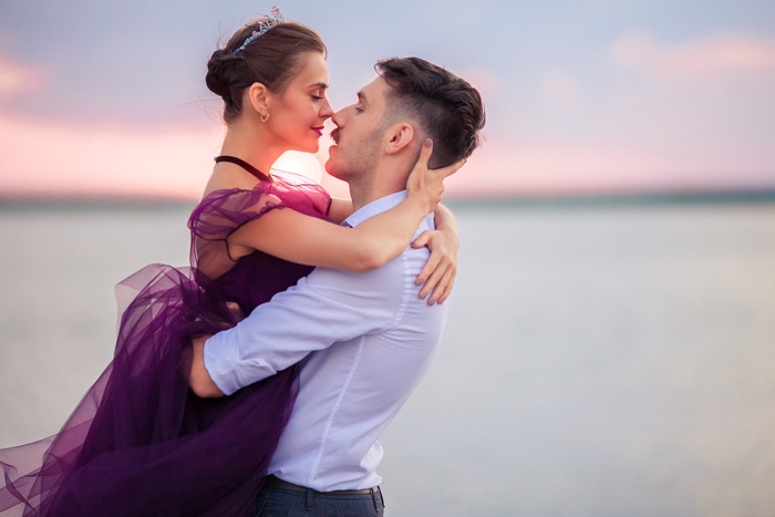young romantic couple relaxing beach watching sunset