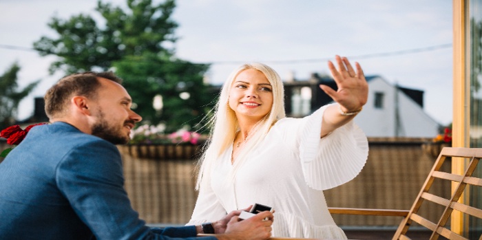 Man looking at her girlfriend showing engagement ring