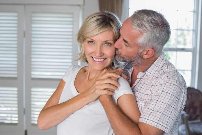 mature man kissing happy woman