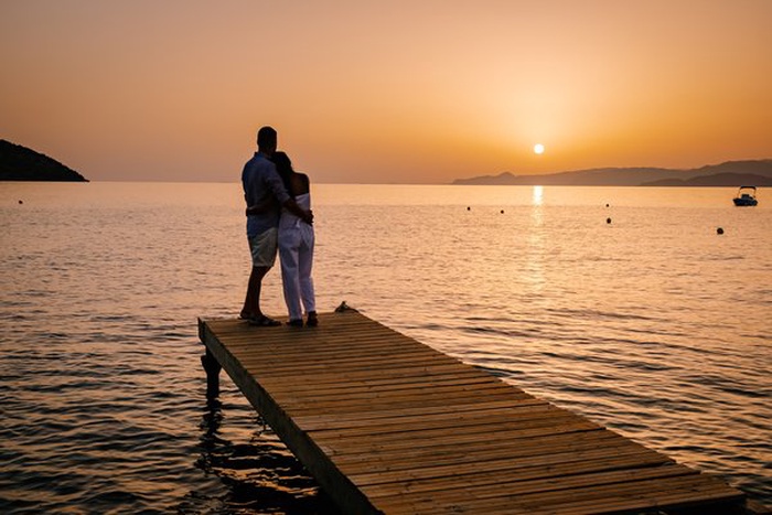 Elegant couple walking by Walled Lake at sunset in Novi, Michigan.
