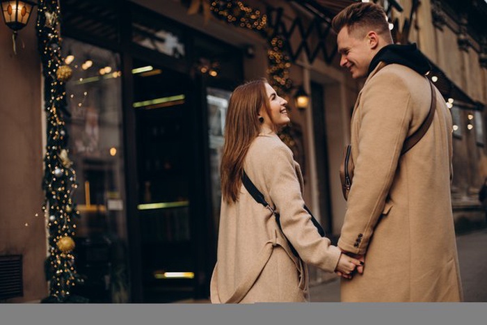 Affluent couple chatting under downtown Woodstock string lights before a first date.