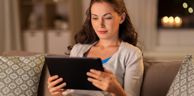 Wealthy woman considering online dating profile on tablet