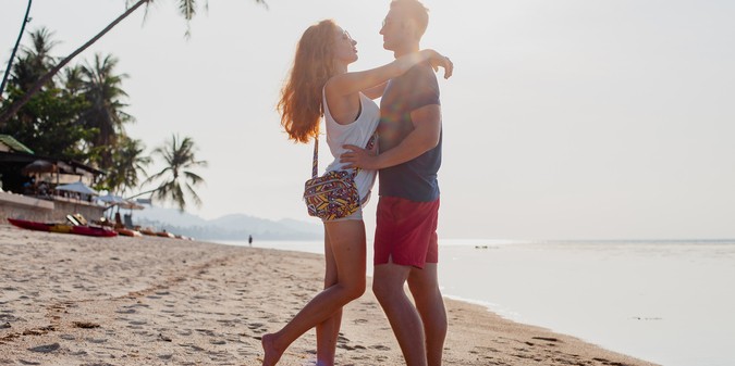 man and woman hugging on the beach