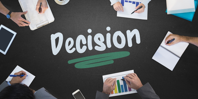 The word decision and business meeting against blackboard