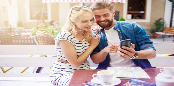 Couple looking at a phone in café