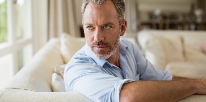 thoughtful man sitting on sofa