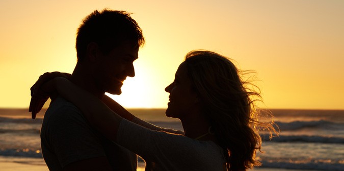 Couple love and smile at beach with sunset