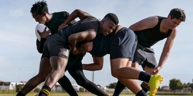 Male athletes playing rugby on the field
