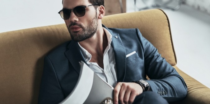 Stylish man in suit reading in luxury setting